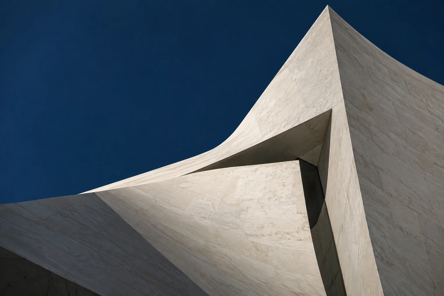 Sculptural white architecture rising against a deep blue sky